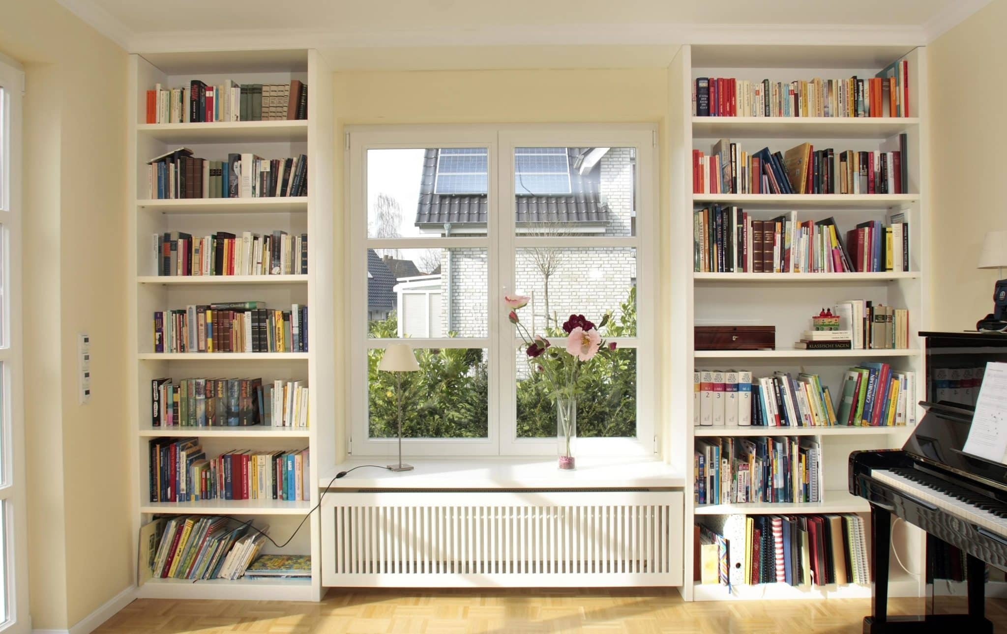 Helles Wohnzimmer mit Bücherregalen und Fenster.